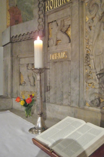 Eine Kerze brennt auf dem Altar.