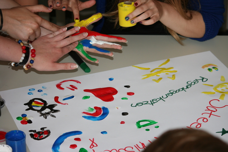 Jugendliche malen mit Fingerfarben.